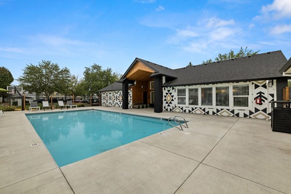 Olympic-size outdoor pool at Cedar House Apartments with spacious deck and loungers for luxury relaxation