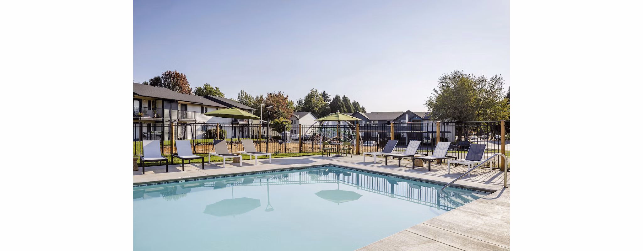 Outdoor pool with lounge chairs at Cedar House Apartments, offering relaxation and leisure in a luxurious setting