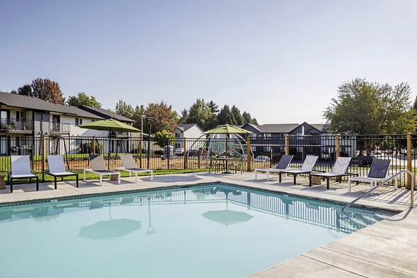 Outdoor pool with lounge chairs at Cedar House Apartments, offering relaxation and leisure in a luxurious setting