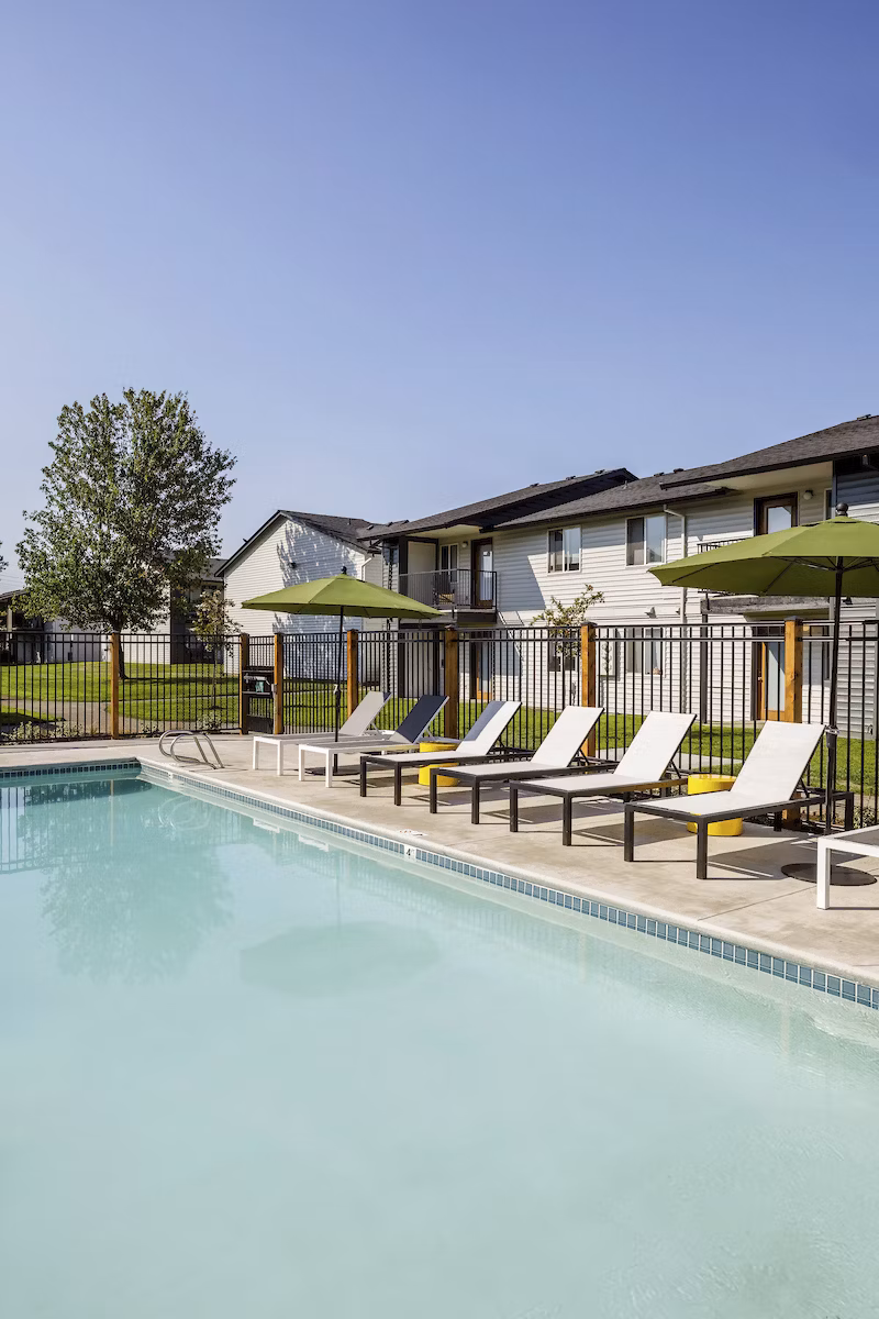 Inviting pool with lounge chairs at Cedar House Apartments offering luxury community living