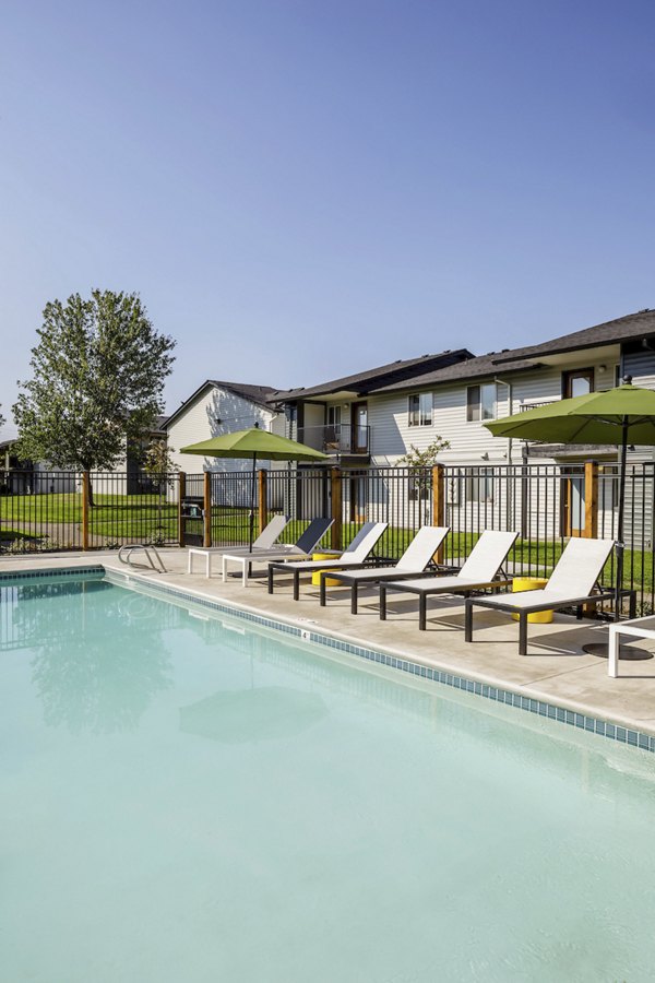 Inviting pool with lounge chairs at Cedar House Apartments offering luxury community living