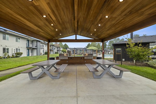 Outdoor dining area with BBQ grills at Cedar House Apartments, perfect for entertaining and enjoying alfresco meals