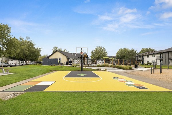 Sport court at Cedar House Apartments: Basketball and tennis court with seating for residents and guests, offering outdoor recreation and exercise opportunities