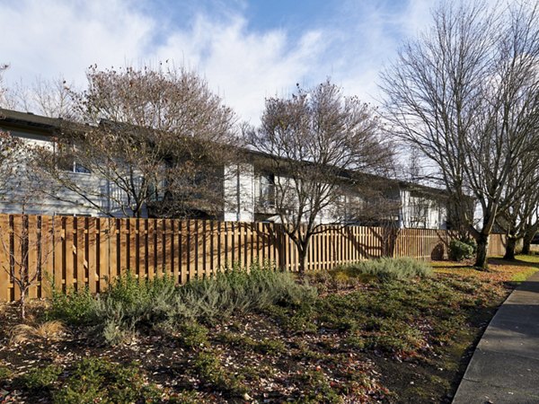 Cedar House Apartments: Serene courtyard with landscaped garden and seating area in a luxury apartment community