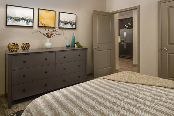 Cozy bedroom with modern decor at Sapphire Bay Apartments, a luxury Greystar property