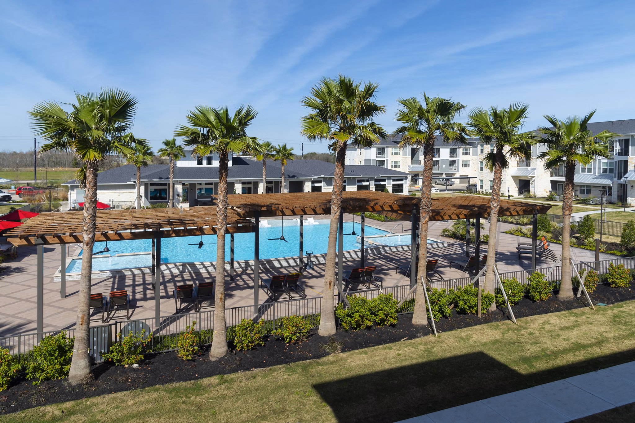 Infinity-edge pool at Sapphire Bay Apartments with palm tree surroundings, offering luxury relaxation and oceanfront views