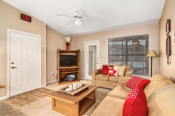 Spacious living room with modern furnishings in Reveille Ranch Apartments, perfect for relaxing and entertaining guests
