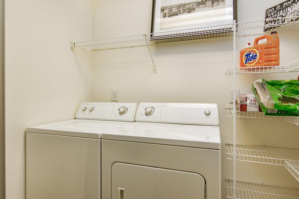 Modern laundry room with energy-efficient machines at Reveille Ranch Apartments