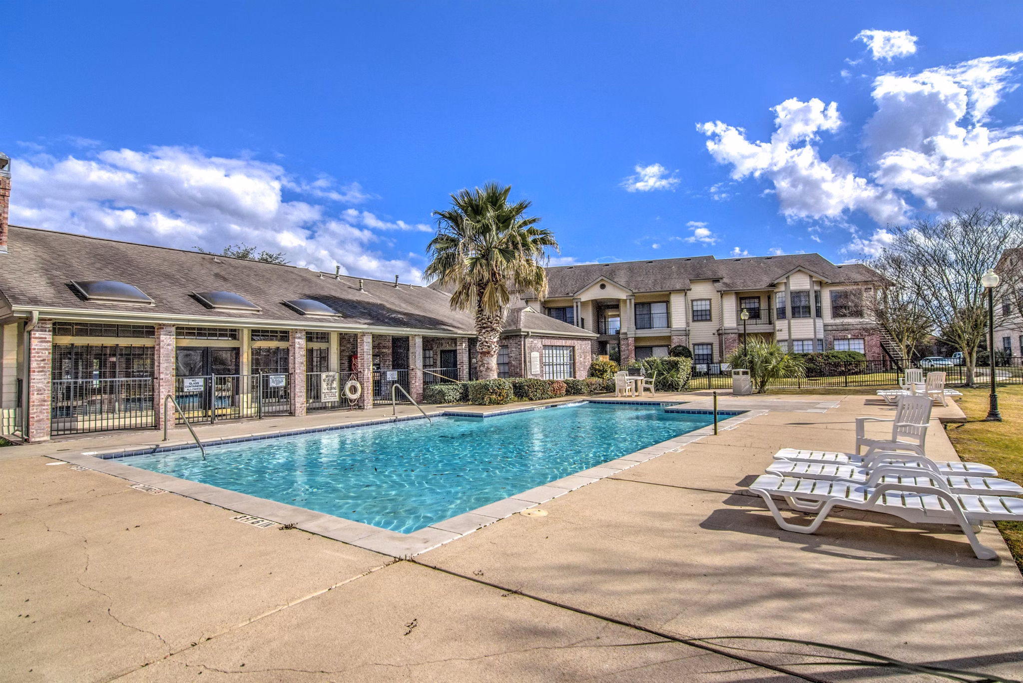 Pool with lounge chairs at The Ridge Apartments