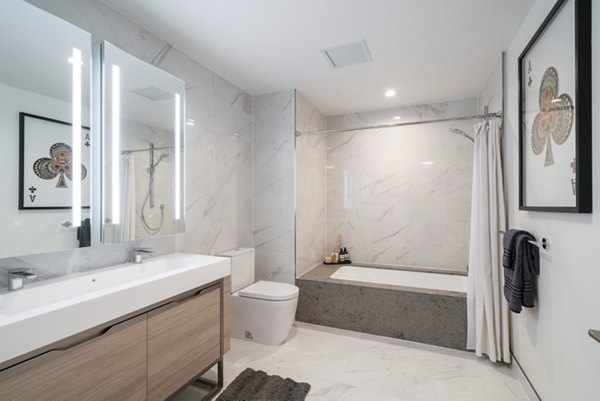 Luxury bathroom with marble countertops and modern fixtures at THEA at Metropolis Apartments