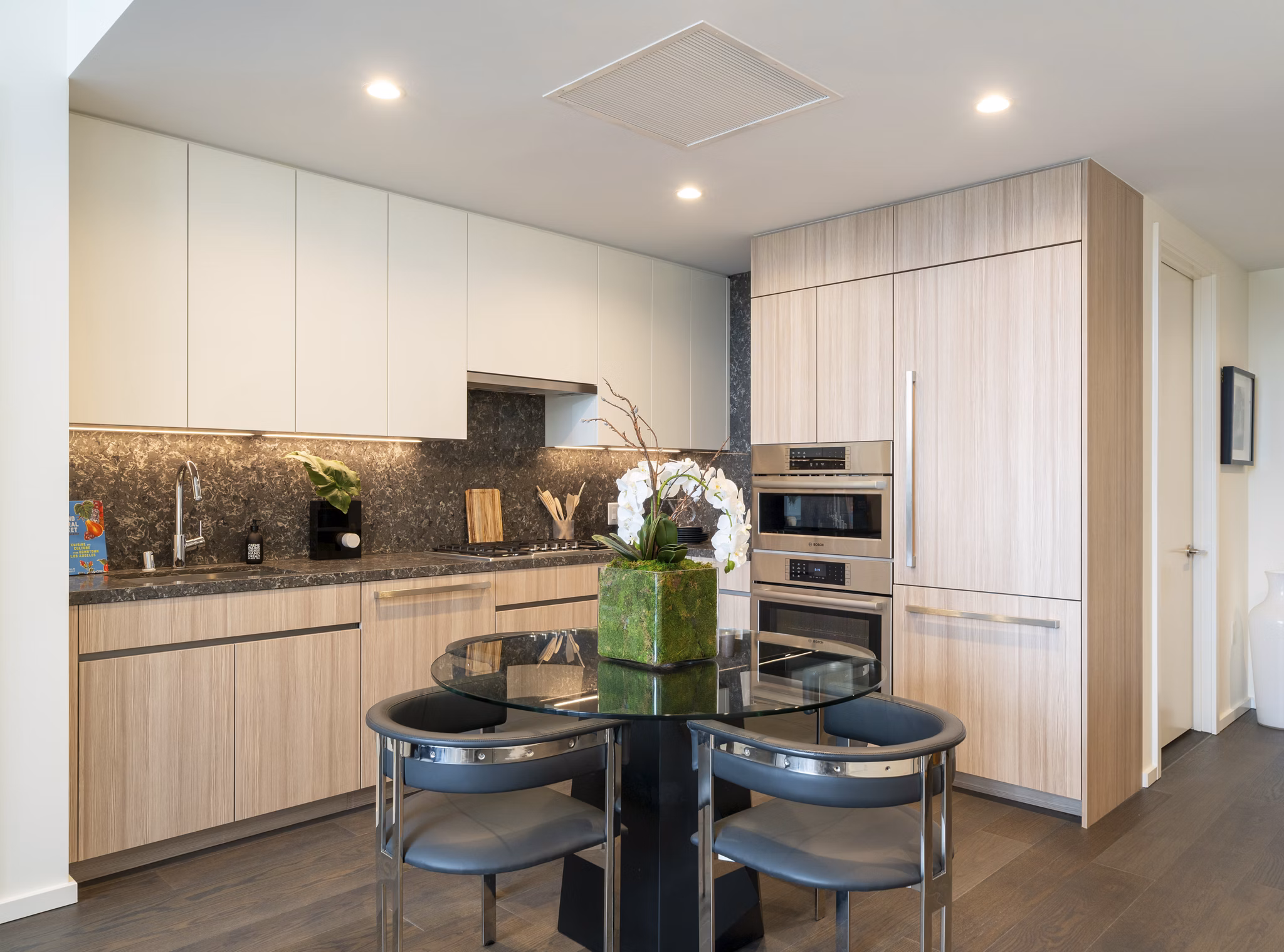 Dining area with elegant decor at THEA at Metropolis Apartments, featuring ample seating and modern lighting