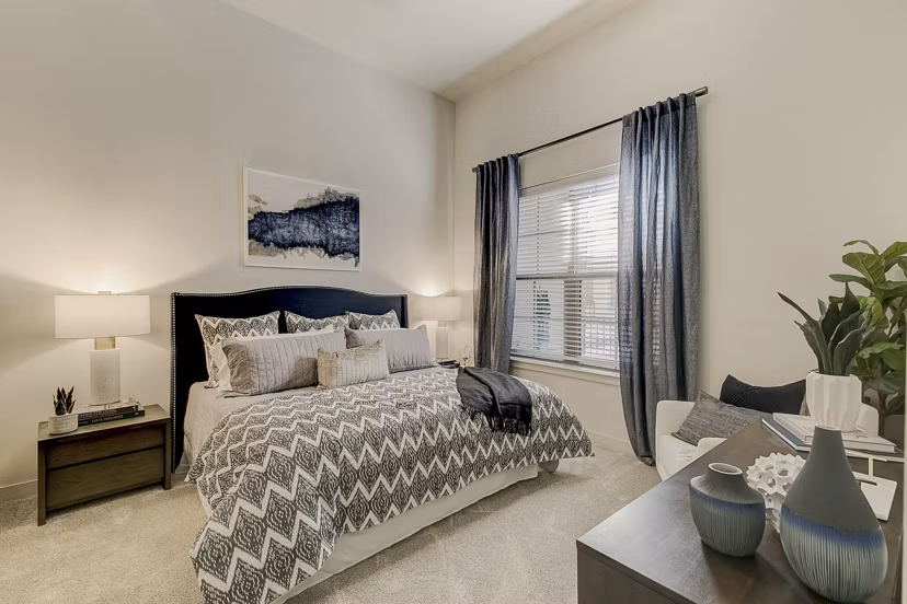 Cozy bedroom with modern decor at Addison Grove Apartments, featuring natural light and spacious layout