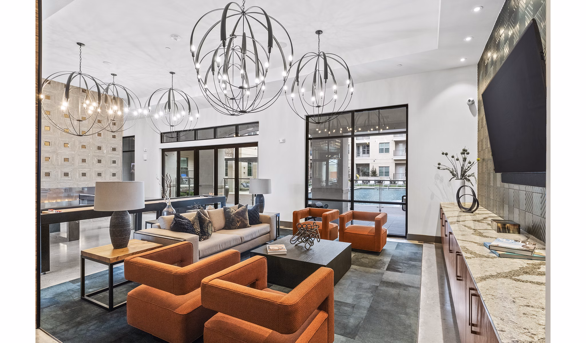 Clubhouse lobby with contemporary furnishings and elegant lighting at Elan Addison Grove Apartments