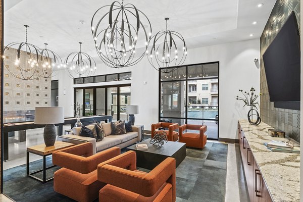 Clubhouse lobby with contemporary furnishings and elegant lighting at Elan Addison Grove Apartments