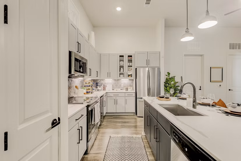 Modern kitchen with stainless steel appliances and granite countertops at Addison Grove apartments