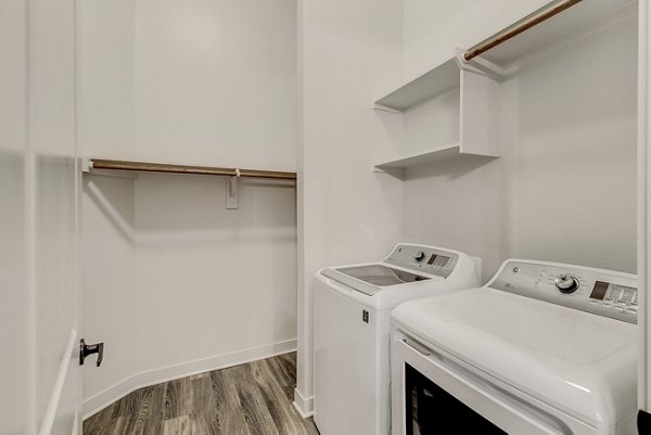 Laundry room with high-efficiency washers and dryers at Elan Addison Grove Apartments
