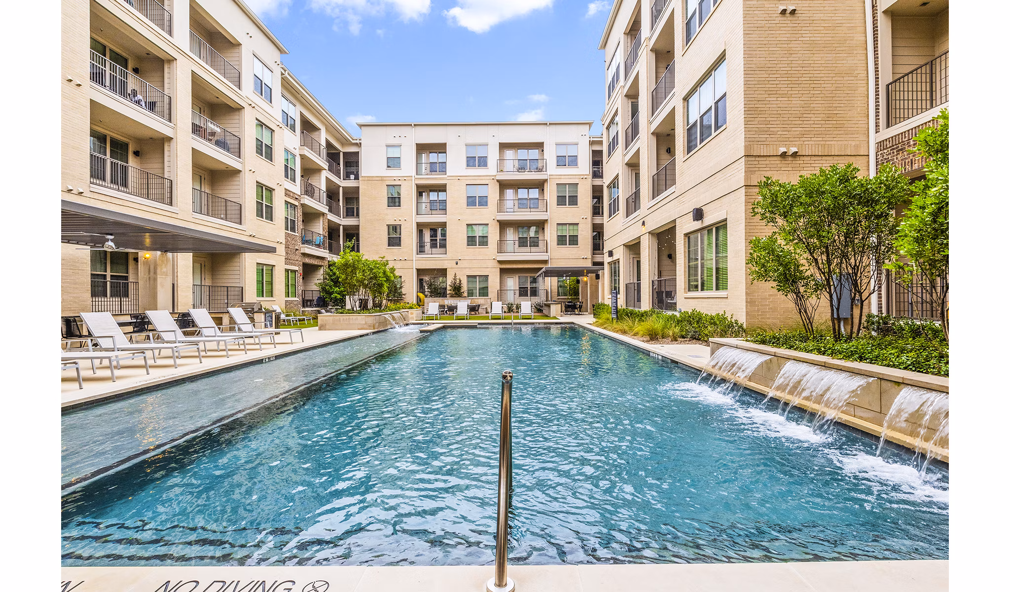 Luxurious pool area with sun loungers at Elan Addison Grove Apartments in Addison, Texas