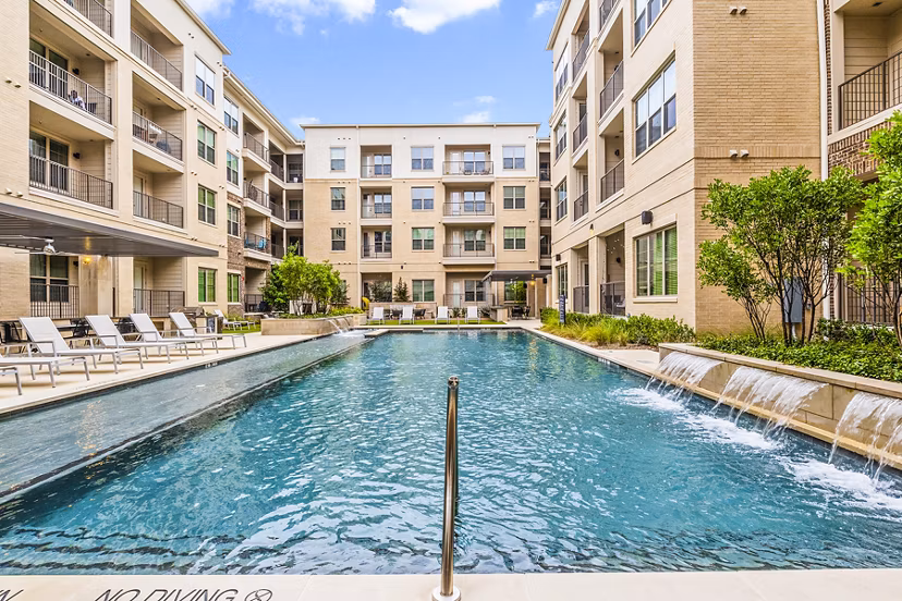 Luxurious pool area with sun loungers at Elan Addison Grove Apartments in Addison, Texas