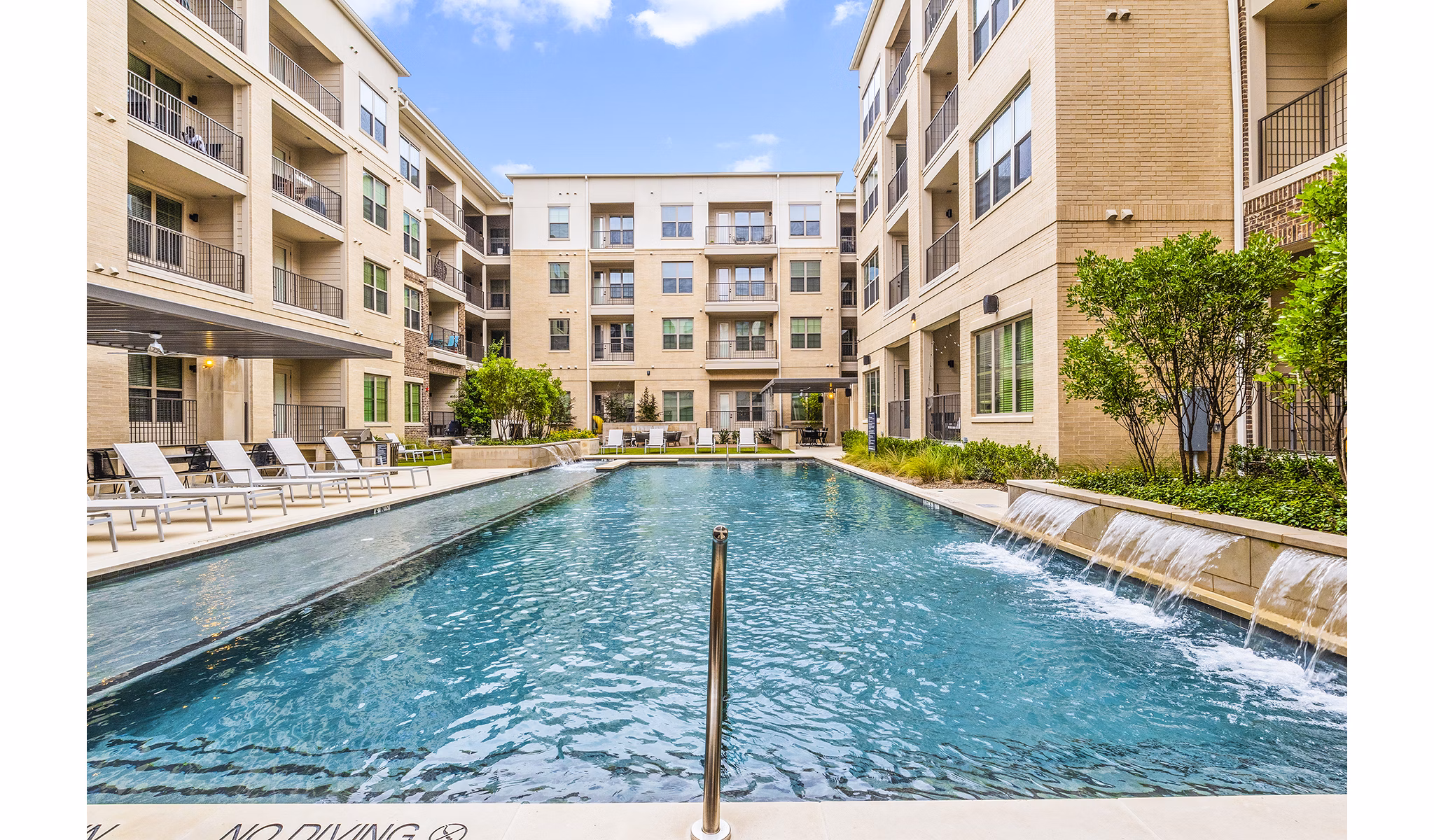 Luxurious pool area with sun loungers at Elan Addison Grove Apartments in Addison, Texas