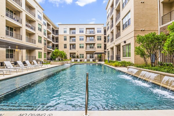 Luxurious pool area with sun loungers at Elan Addison Grove Apartments in Addison, Texas