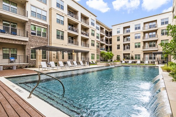 Glistening pool at Elan Addison Grove Apartments with modern sundeck for residents seeking luxury living in Addison
