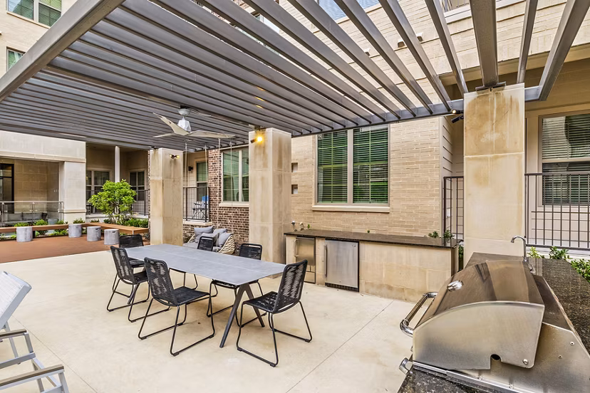 Modern grill area with seating at Elan Addison Grove Apartments, perfect for outdoor dining and entertaining