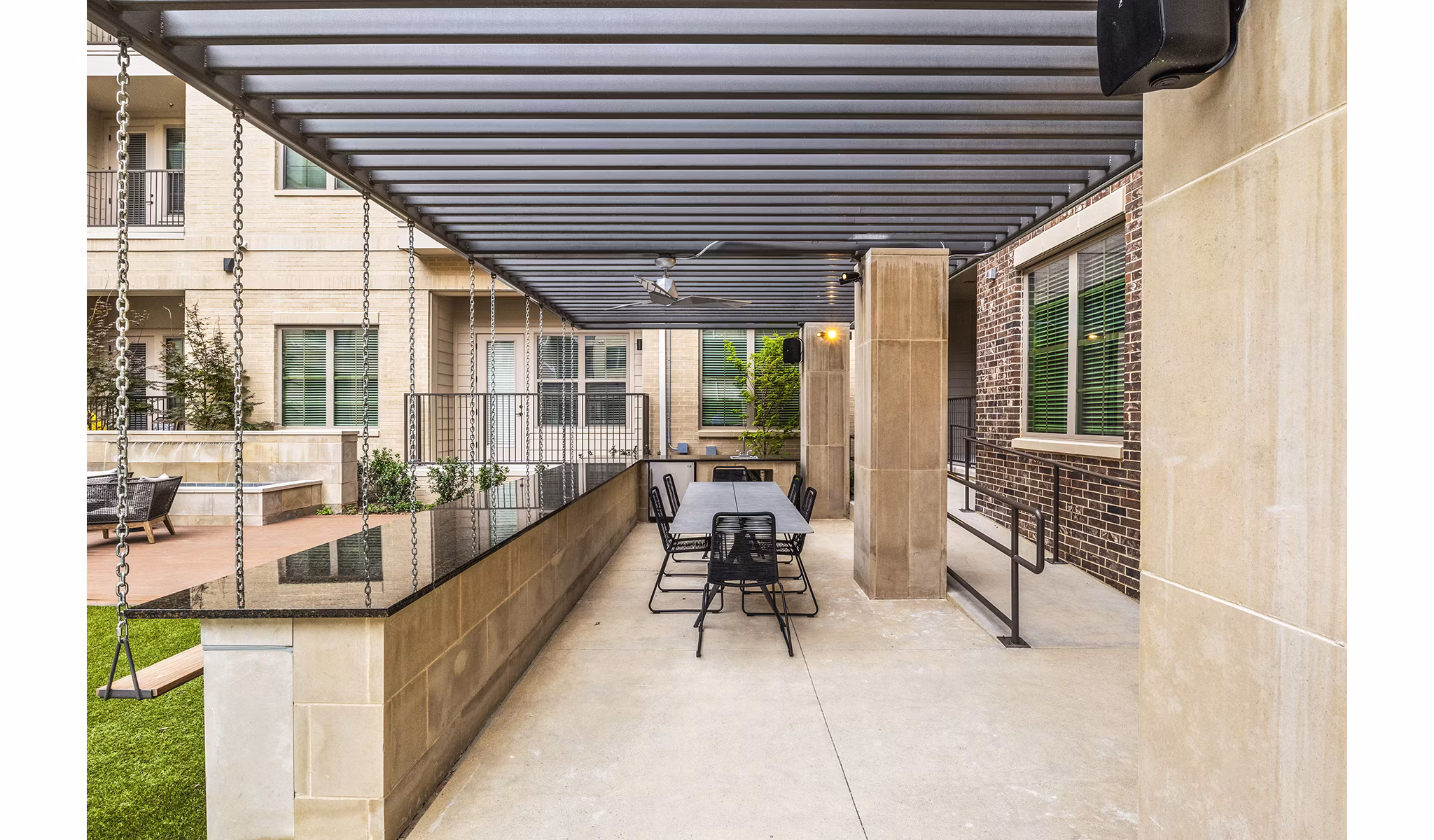 Outdoor BBQ grill area with seating at Elan Addison Grove Apartments