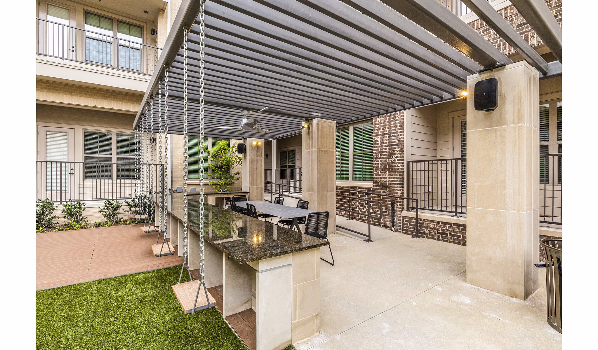 BBQ grill area at Elan Addison Grove Apartments: Modern outdoor space with seating and pergolas for social gatherings