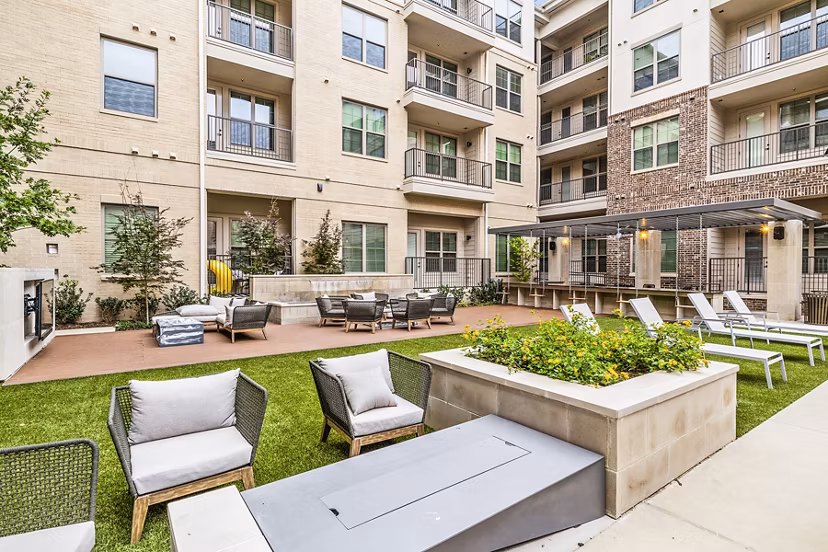 Elan Addison Grove Apartments: Spacious patio with outdoor seating and greenery