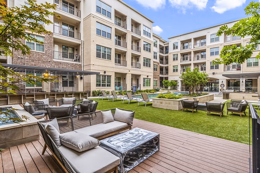 Outdoor pool and patio with lounge chairs at Elan Addison Grove Apartments