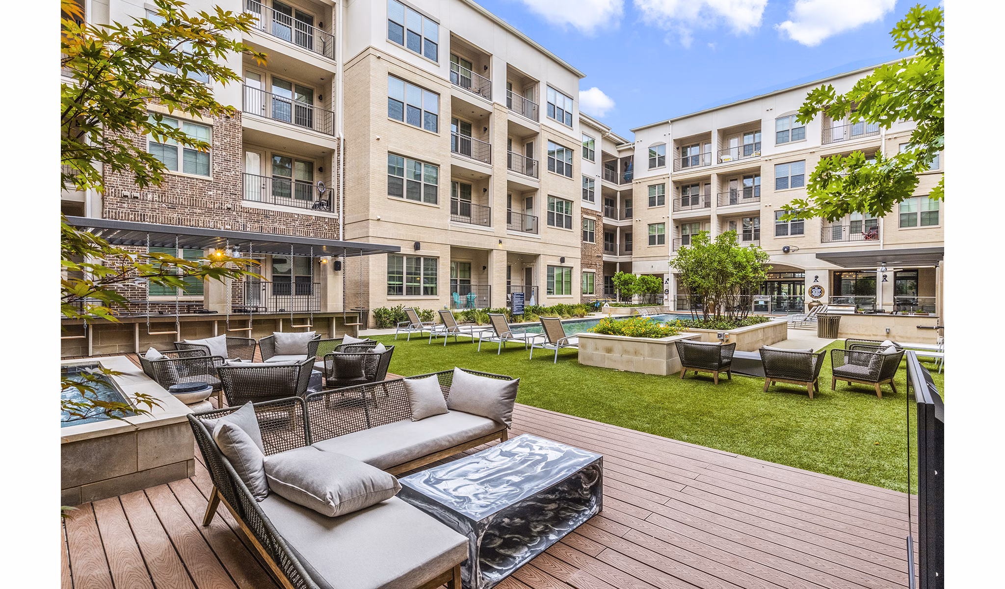 Outdoor pool and patio with lounge chairs at Elan Addison Grove Apartments