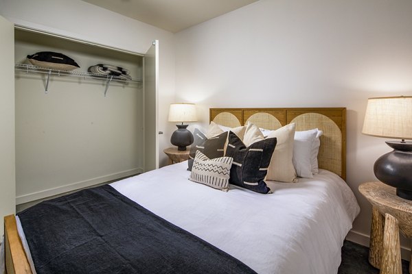 Bedroom with modern furnishings and large windows at Be DTLA Apartments, a luxurious living space in the heart of downtown Los Angeles