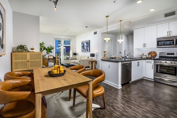 Dining room featuring modern decor and large windows in Be DTLA Apartments
