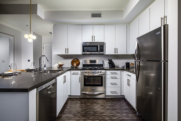 Modern kitchen with sleek countertops and stainless steel appliances in Be DTLA Apartments