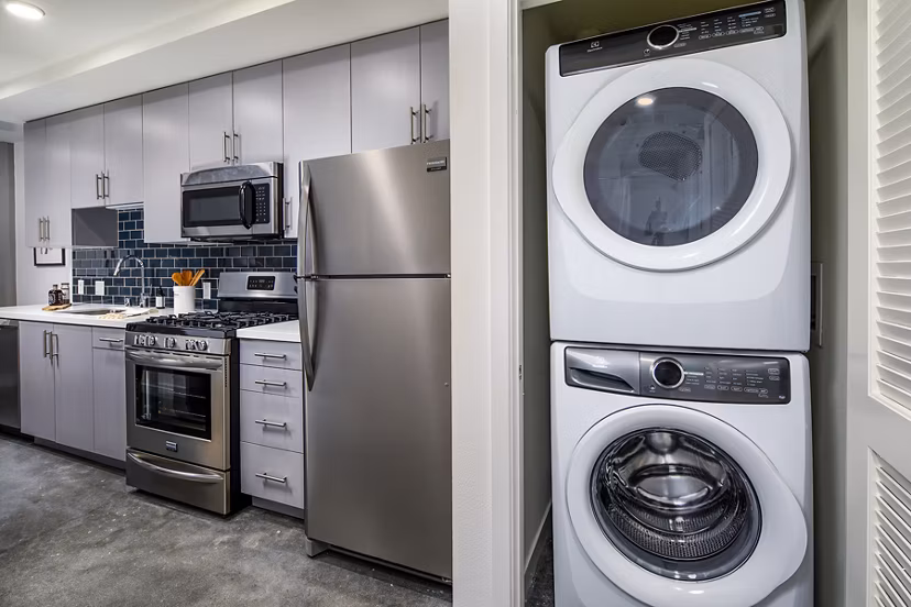 Modern kitchen featuring stainless steel appliances and granite countertops at Be DTLA Apartments