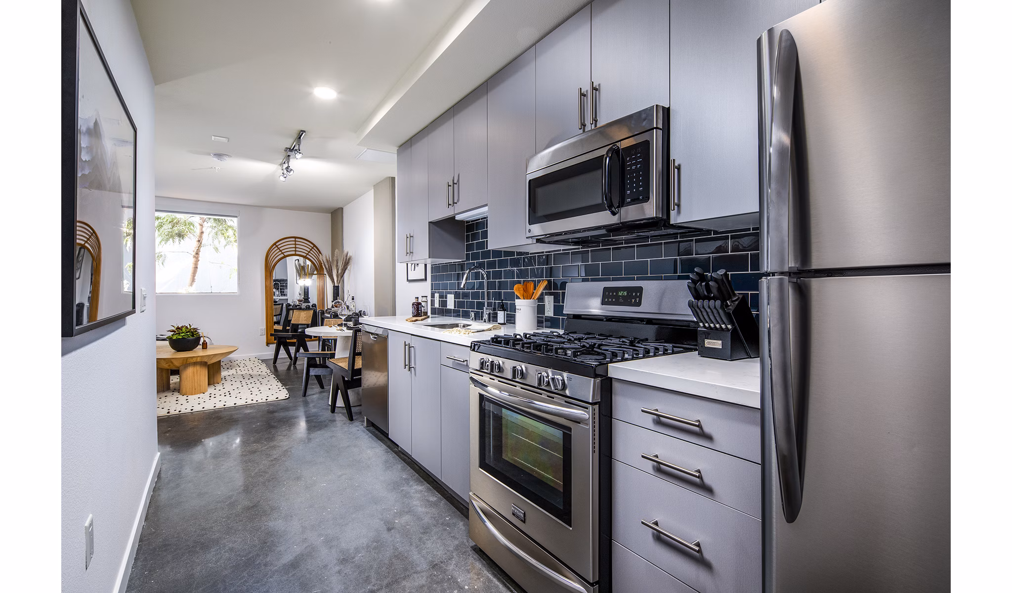 Modern kitchen with stainless steel appliances and island counter in Be DTLA Apartments