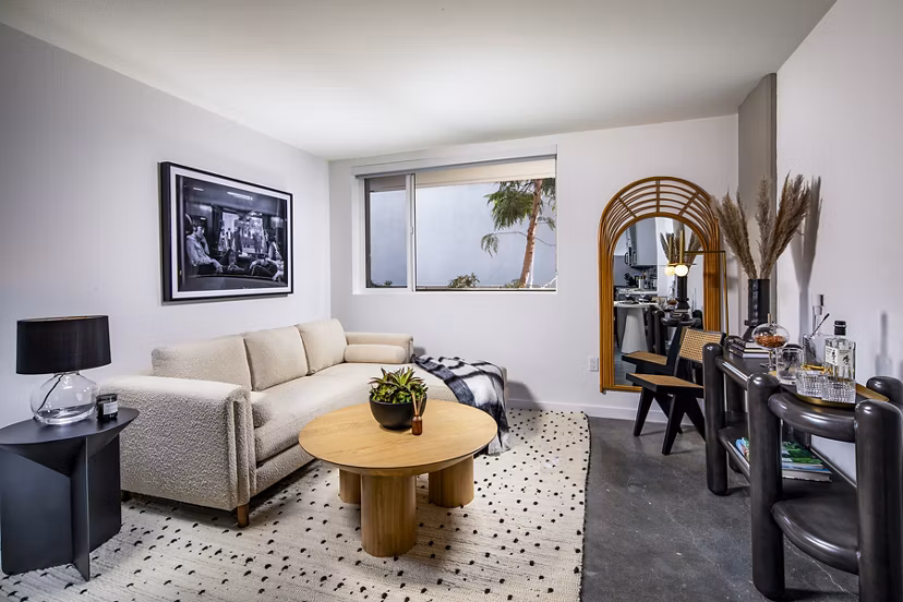 Modern living room with chic decor and ample natural light at Be DTLA Apartments