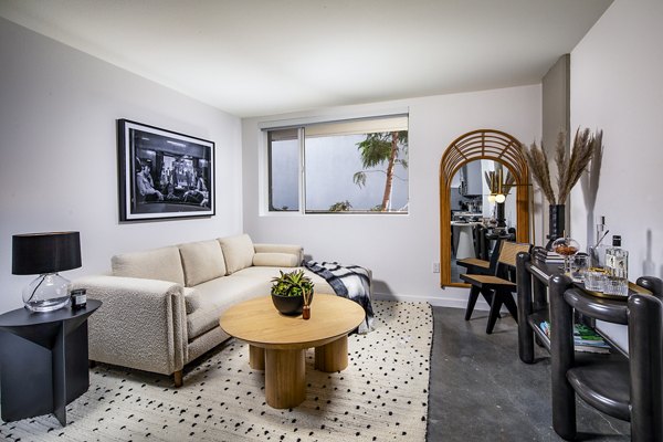 Modern living room with chic decor and ample natural light at Be DTLA Apartments