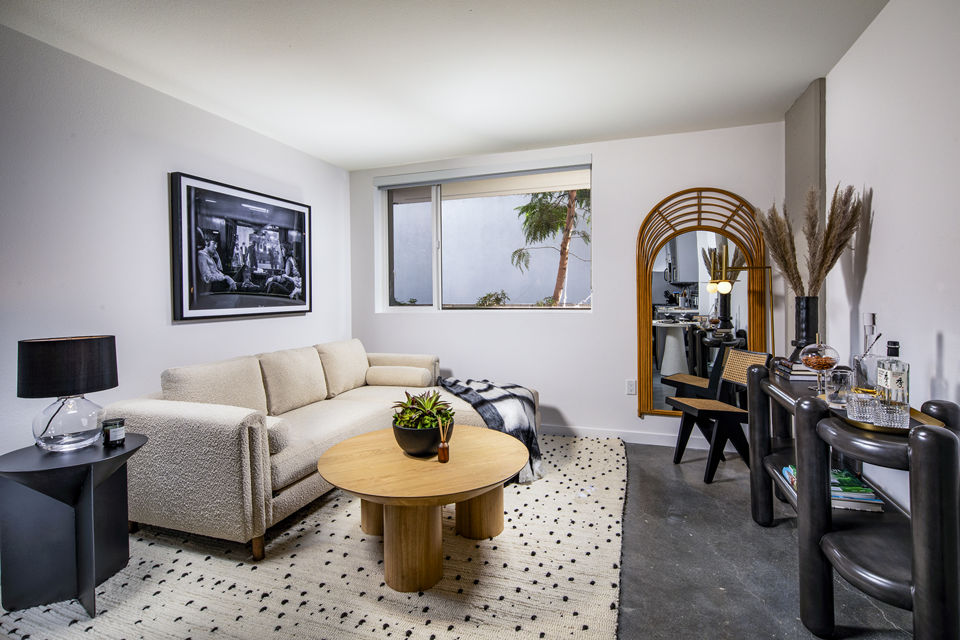 Modern living room with chic decor and ample natural light at Be DTLA Apartments