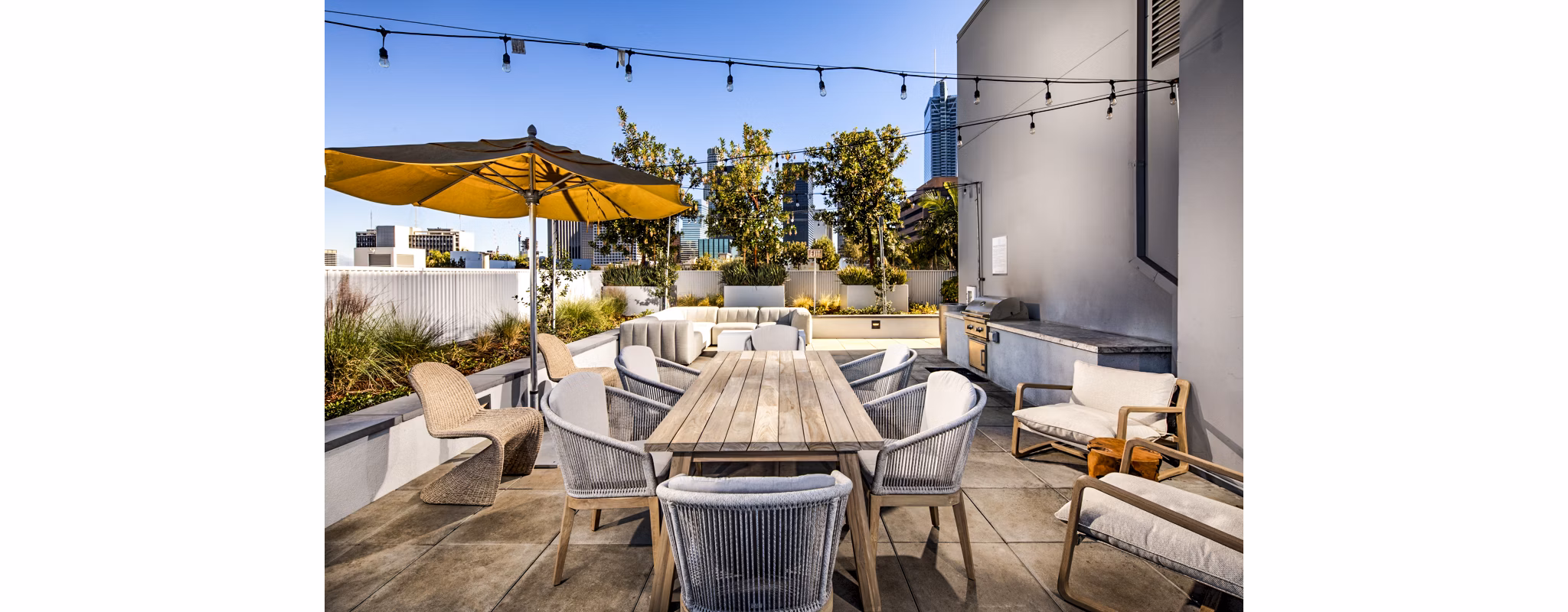 Grill area with modern BBQ setup at Be DTLA Apartments