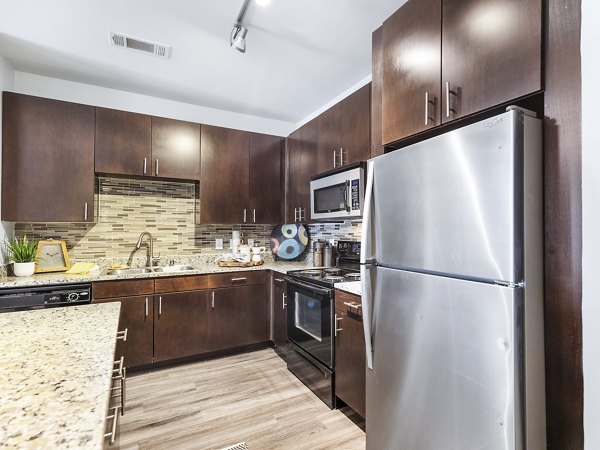 Modern kitchen with stainless steel appliances at The Avery on Southwestern Apartments