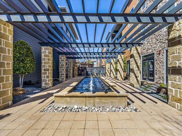 Patio with modern seating and lush landscaping at The Avery on Southwestern Apartments, offering luxury outdoor relaxation spaces