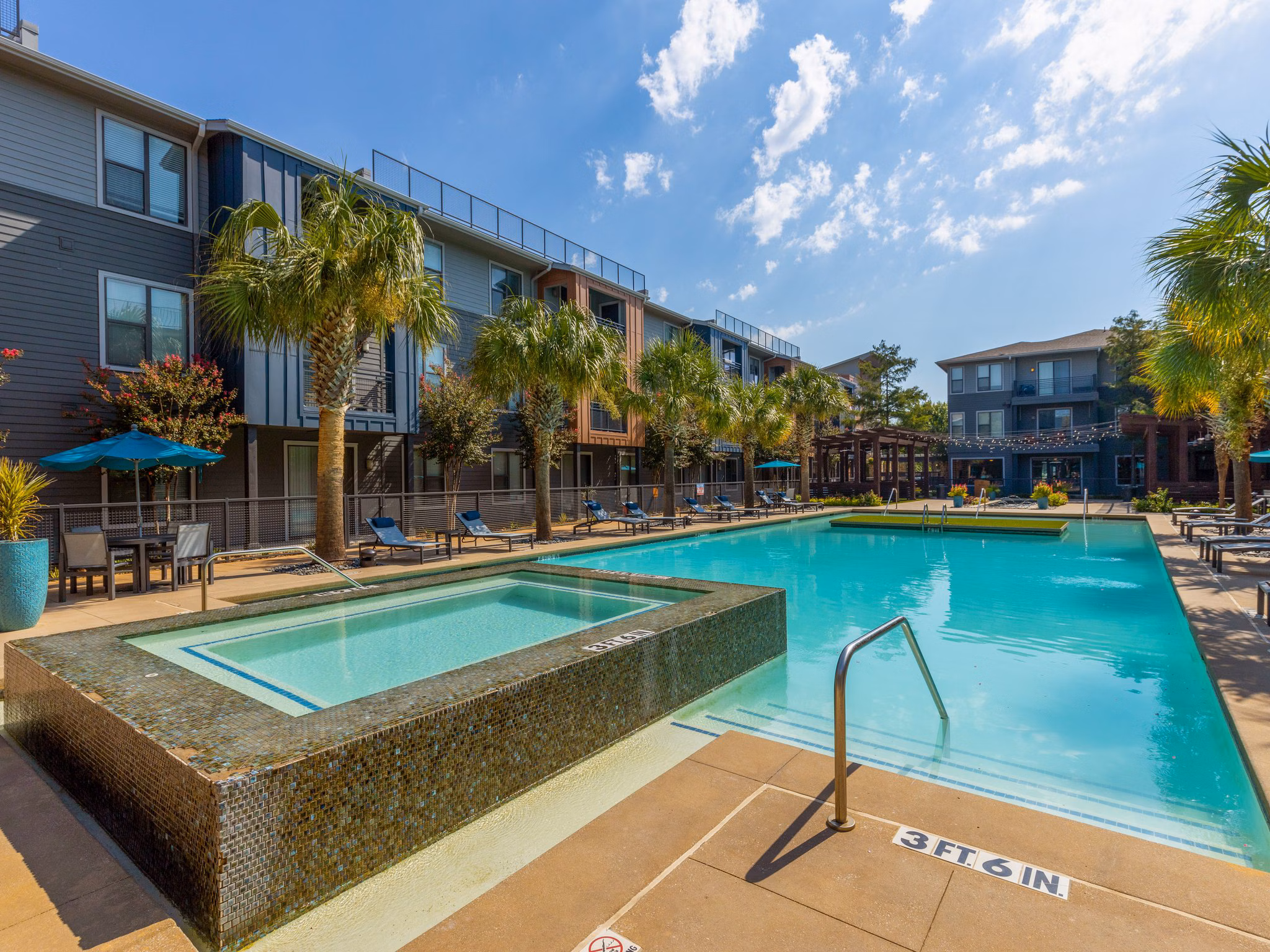 Resort-style pool with sun loungers at The Avery on Southwestern luxury apartments