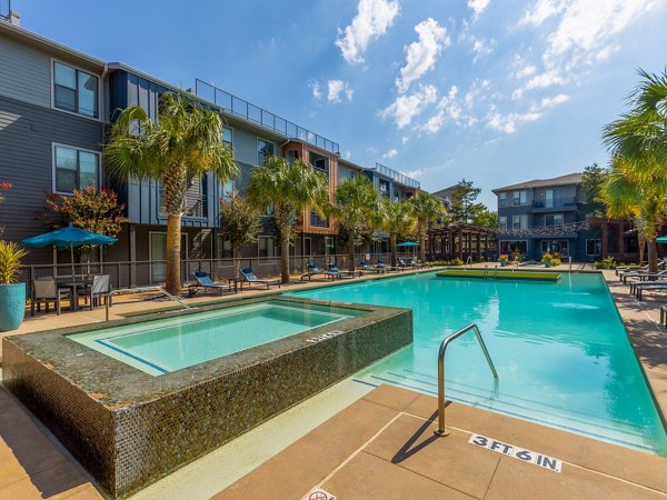 Resort-style pool with sun loungers at The Avery on Southwestern luxury apartments