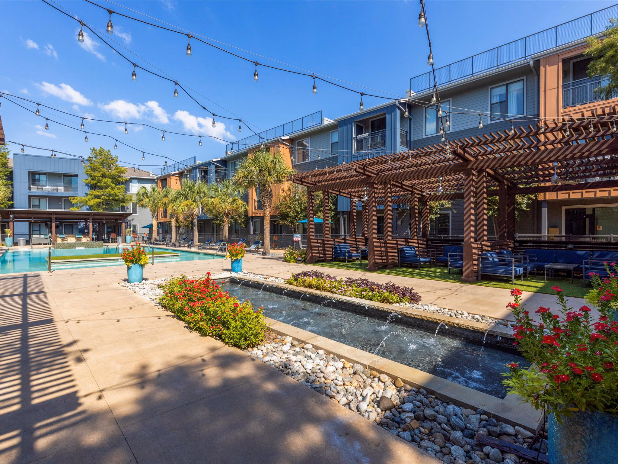 Courtyard with lush greenery and seating at The Avery on Southwestern Apartments, luxury Greystar community in a tranquil setting