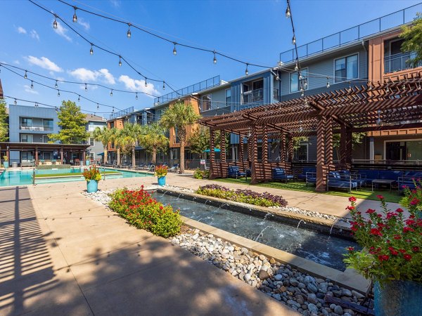 Courtyard with lush greenery and seating at The Avery on Southwestern Apartments, luxury Greystar community in a tranquil setting
