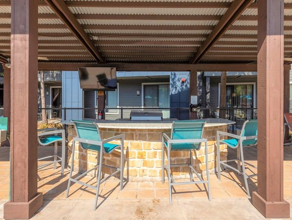 Outdoor grilling area at The Avery on Southwestern Apartments featuring modern BBQ facilities