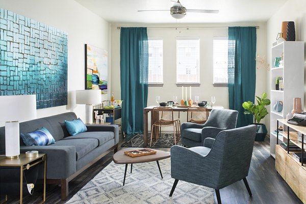 Cozy living room with modern decor at Griffis at Lowry Apartments, featuring plush seating and a stylish coffee table