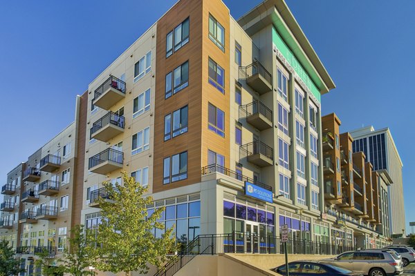 Modern multi-story luxury apartments with balconies and commercial space in a vibrant urban setting