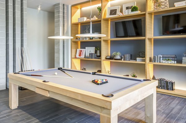 Modern game room with pool table and lounge seating at Loren Apartments